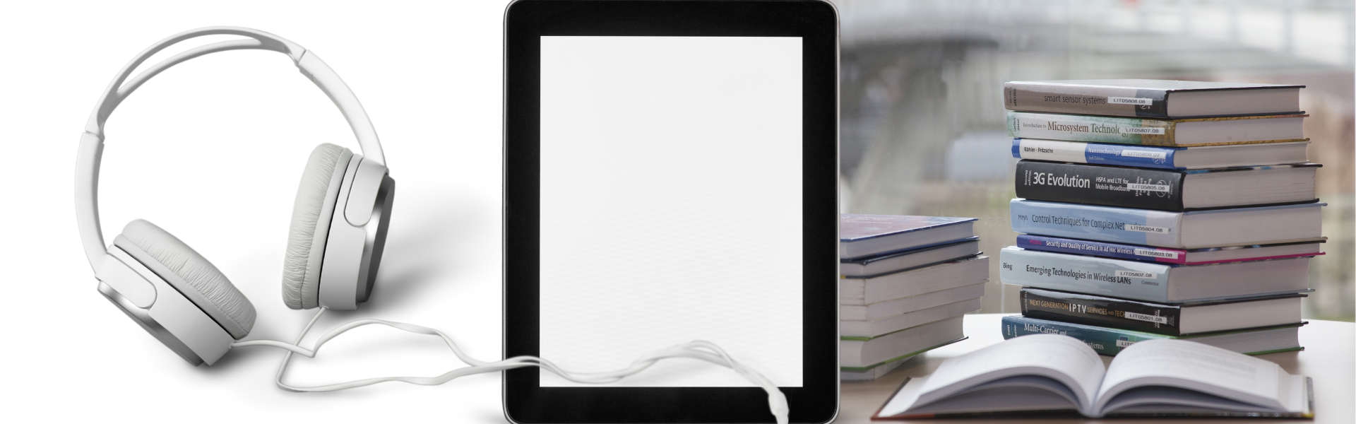 stack of books piled up with tablet in front and headphones