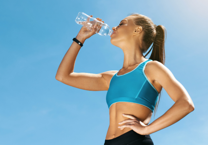 A runner is drinking from a bottle of water.