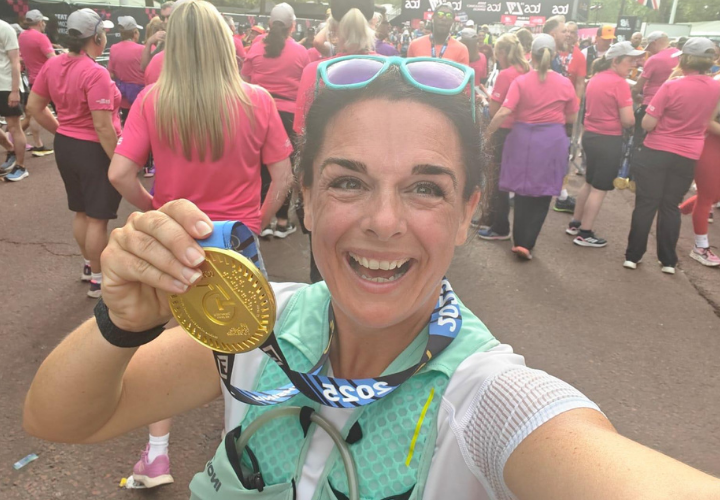 Louisa doing a selfie holding up her finishers' medal at the London marathon