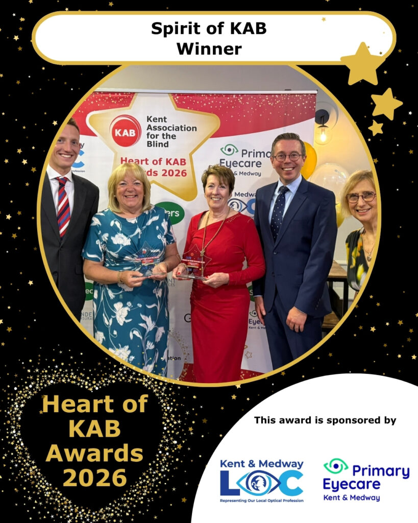 Two Iris volunteers (Marguerite and Barbara) stand with their trophies next to the award sponsors Kent and Medway Local Optical Committee and Primary Eyecare.