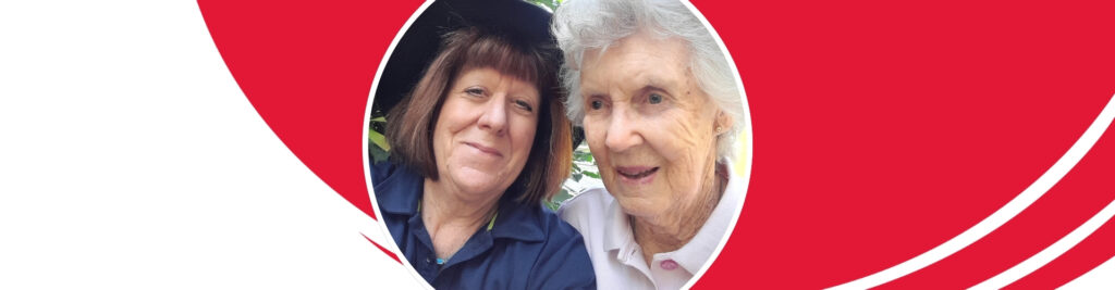 Volunteer Sally close to client Jo and smiling to camera.